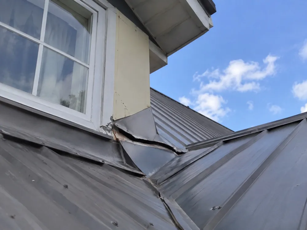 Lifted and damaged metal roof flashing